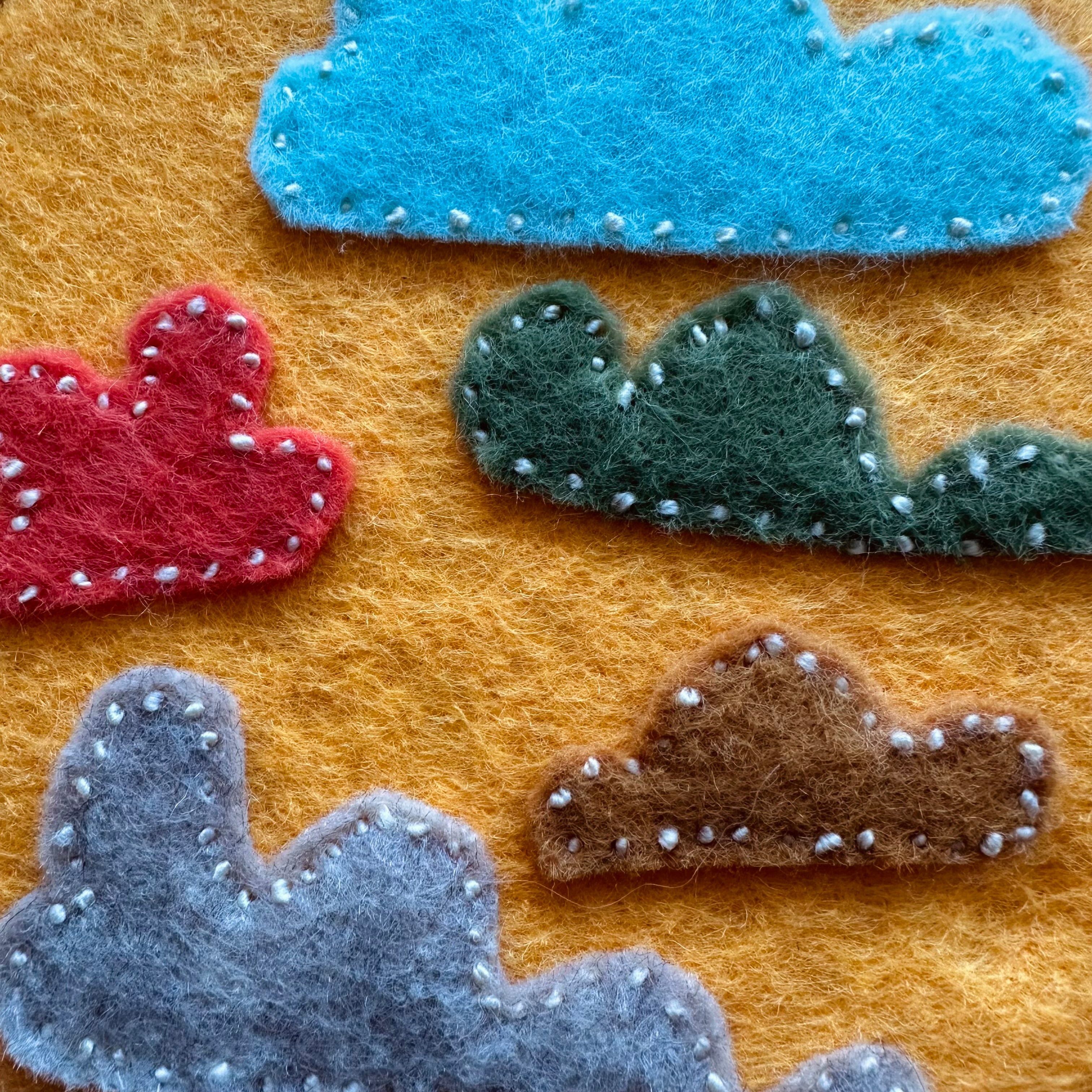 Felt cloud embroidery on hoop, yellow