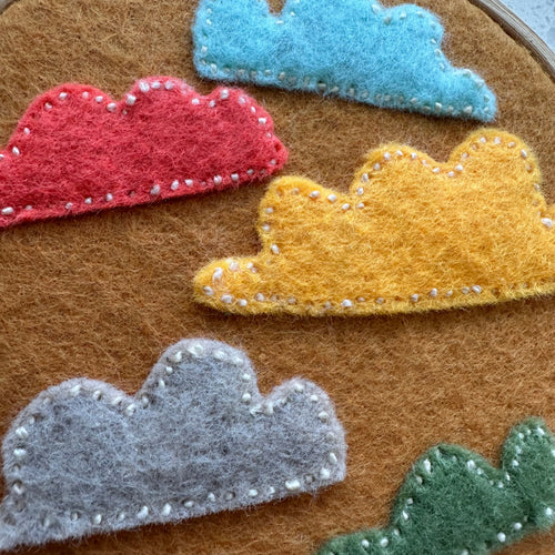 Felt cloud embroidery on hoop, burnt yellow/orange