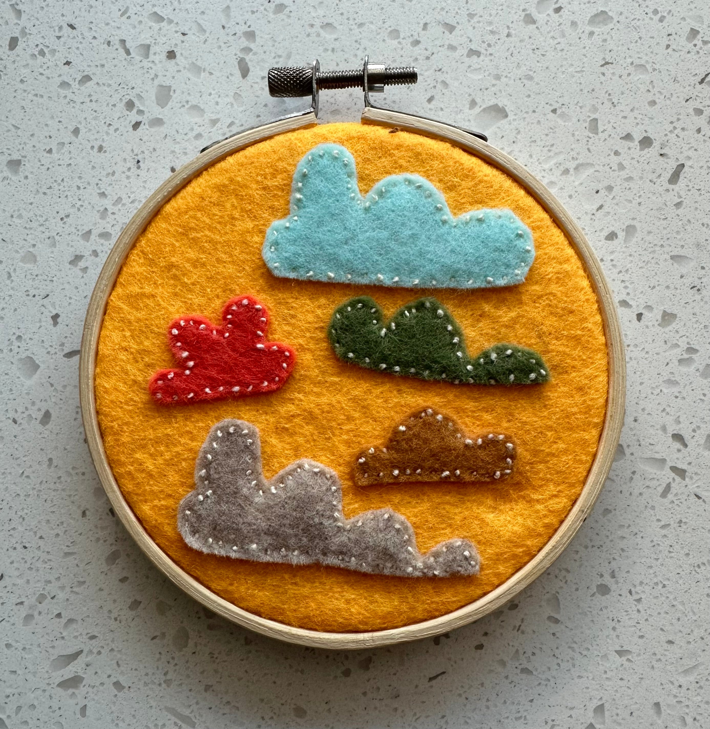 Felt cloud embroidery on hoop, yellow